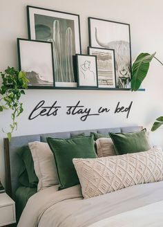 there is a bed with pillows and pictures on the wall above it that says let's stay in bed