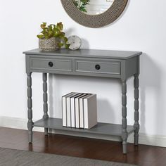 a grey console table with two drawers and a mirror on the wall