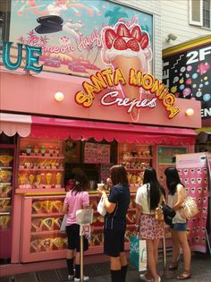 people standing in front of an ice cream shop with pink walls and signs on it