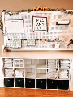 a white shelf filled with lots of towels and other items on top of a wooden floor