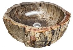 a wooden bowl shaped sink with a white faucet in the center and brown wood grain