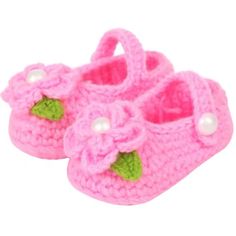 a pair of pink crocheted baby shoes with pearls on the bottom and green leaves