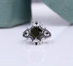 a black and white diamond ring sitting on top of a table