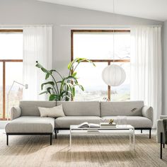 a living room filled with furniture and large windows