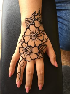 a woman's hand with henna tattoos on it