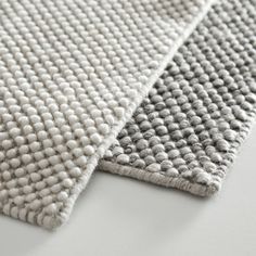 two white and grey rugs on top of each other