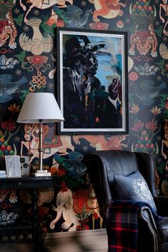 a chair and lamp in front of a wallpapered room with an animal theme