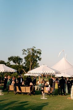 a group of people standing under white tents