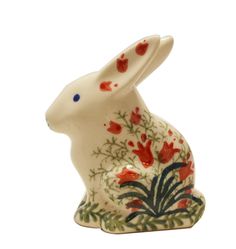 a white rabbit figurine with red flowers on it