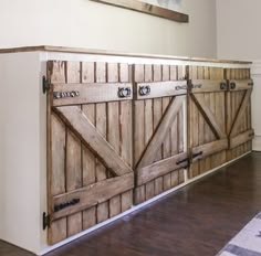 a large wooden cabinet sitting on top of a hard wood floor next to a white wall