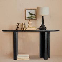 a black table with a lamp and some books on the shelf in front of it