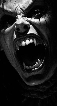 an evil looking man with his mouth open and teeth wide open in black and white