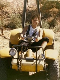 a man riding on the back of a yellow vehicle