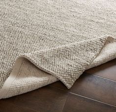 a close up of a rug on the floor with a wooden floor in front of it