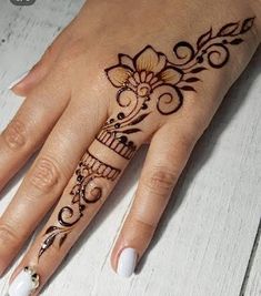 a woman's hand is decorated with hennap and flower designs on it