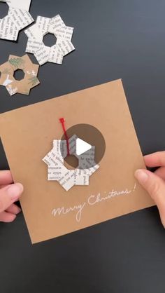 someone is holding up a card made out of paper and cut it into small shapes