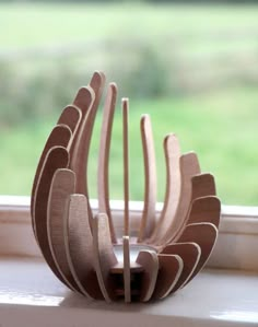 a wooden sculpture sitting on top of a window sill