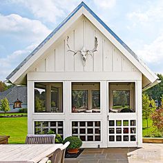 a white house with an attached patio and dining table