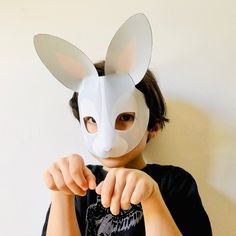 a person wearing a bunny mask and pointing at the camera with their hand in front of her face