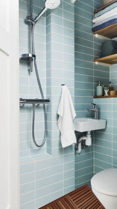 a bathroom with blue tiles and wooden flooring