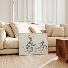 a living room with a couch, coffee table and drawing on the floor in front of it