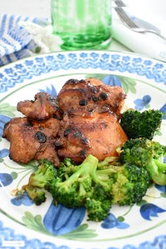 chicken thighs and broccoli on a blue and white plate