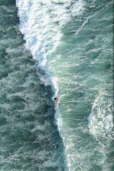 a man riding a wave on top of a surfboard