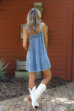 Mini denim dress. Medium wash. Square neckline. Thick tank straps secured with bow detailing in the back. Material: 90% Cotton, 10% Viscose. Sizing: Small: US Size 0-2 Medium: US Size 4-6 Large: US Size 8-10 Model Measurements: Height: 5’11” Chest: 32” Waist: 26” Hips: 36” Wearing size small. Dresses For Country Concert, Denim Vest With Dress, Country Girl Outfits Summer, Denim Dress With Boots, Barn Dance Outfit, Denim Dress Outfit Ideas, Dress With Cowgirl Boots, Dress With Cowboy Boots, Western Summer Outfits