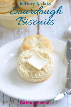 buttery and flaky sourdough biscuits on a white plate