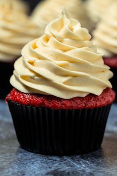 cupcakes with white frosting sitting on a table