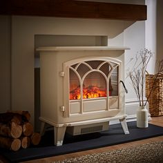 a white stove sitting in the middle of a living room next to a pile of logs