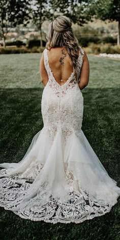 the back of a bride's dress as she stands on grass