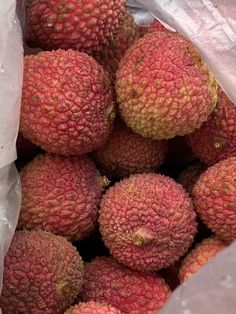 a bag full of red fruit sitting on top of a table