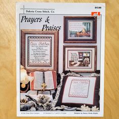 a cross stitch book with pictures and other items on the cover, sitting on a wooden table