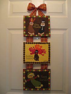 three thanksgiving cards hanging on the front door with a bow around it's neck