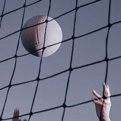 two hands reaching up to catch a volleyball