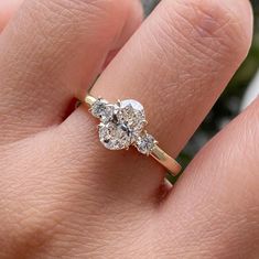 a woman's hand with a diamond ring on top of her finger and an engagement band