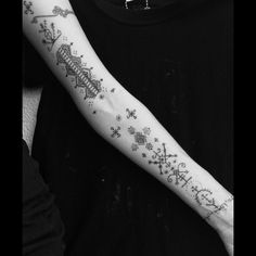 a person with a tattoo on their arm that has snowflakes all over it