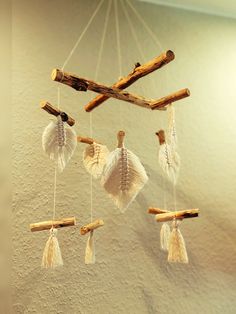 a mobile made out of driftwood sticks and seashells hanging from the ceiling