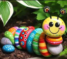 a group of colorfully painted eggs sitting next to each other on top of dirt