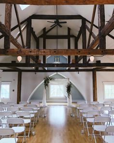 an empty room with white chairs and wooden flooring is seen in this image from the front