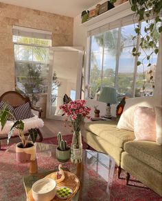 a living room filled with lots of furniture and plants on top of a coffee table