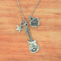 a guitar necklace with two charms attached to it