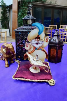 a table topped with an elephant figurine next to a lamp and other items