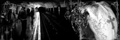 black and white photograph of people walking down train tracks