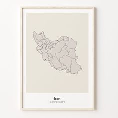 a framed map of the country of iran in grey on a white wall above a wooden frame