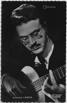 a man with glasses playing an acoustic guitar