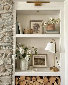 the shelves in this room are filled with books and flowers, including white hydrangeas