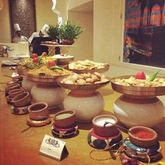 a table topped with lots of bowls filled with food