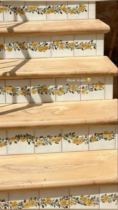 the stairs are painted with yellow flowers and leaves on them, along with white tiles